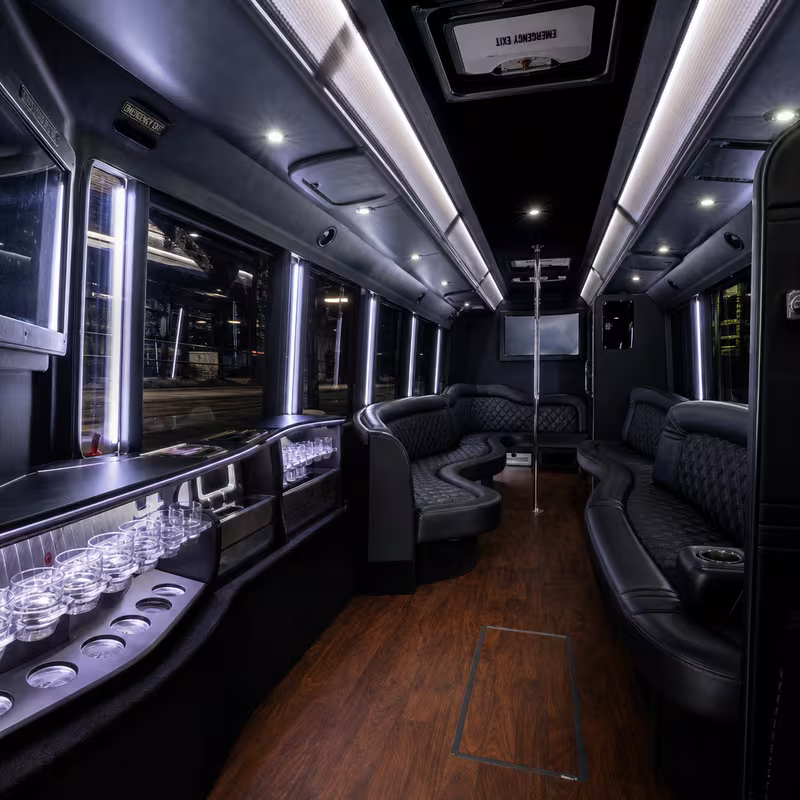 Party bus interior with wraparound leather seating and LED lighting in Kansas City