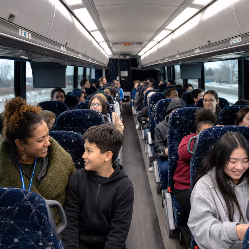 Group boarding a white charter bus for School Transportation transportation in Kansas City